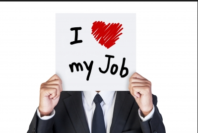 A man covering his face with a placard saying i love my job