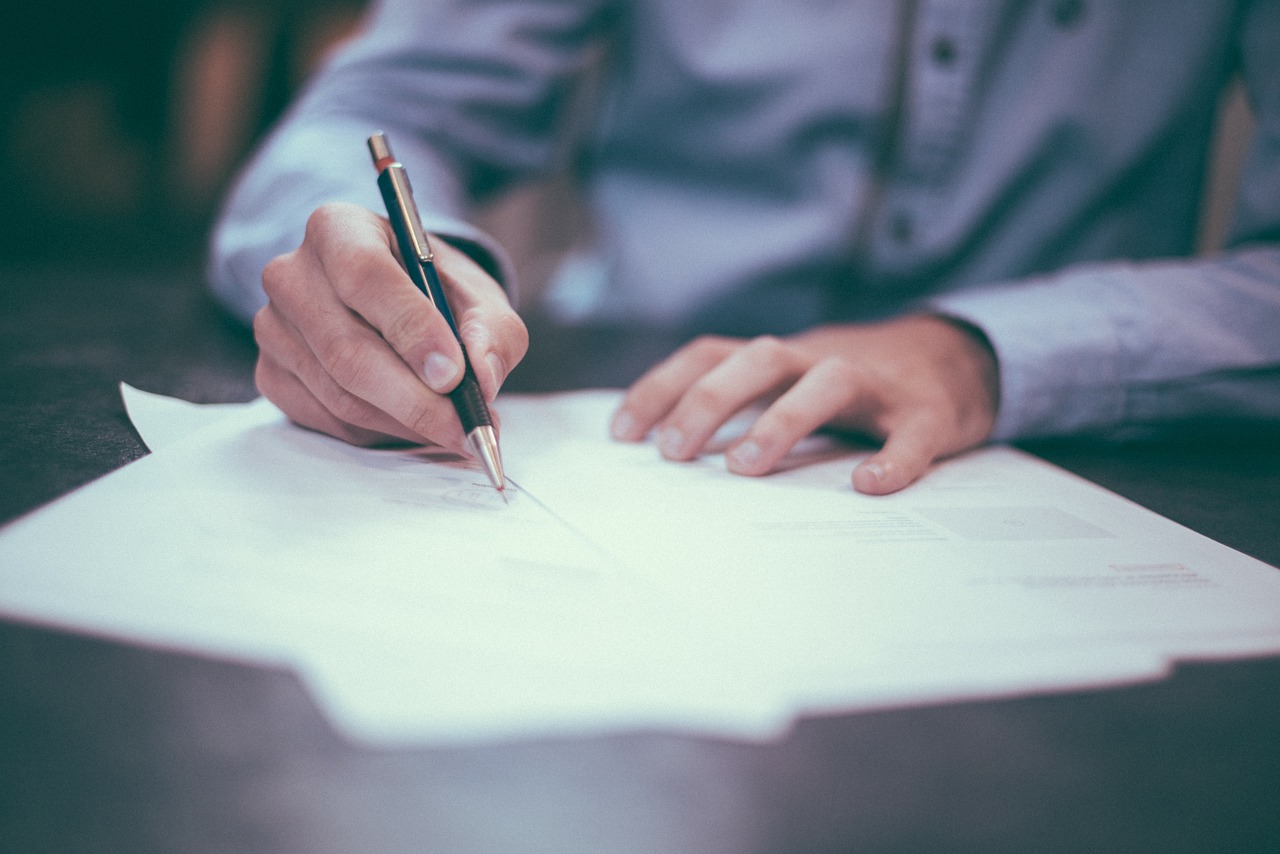 A mans hand holding a pen test taker